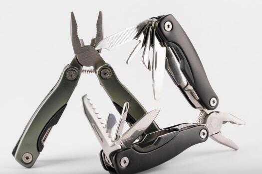 Steel multitool isolated on white background. Opened multitool with pliers, file, blade, screwdriver, bottle opener and saw, with a white background. Multi tool with expanded tools and pliers photo
