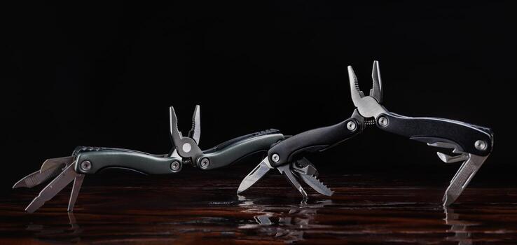 Steel open multitool on red background. Multitool with many useful tools. photo