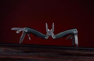 Steel open multitool on red background. Multitool with many useful tools. photo