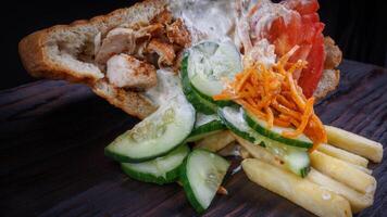 Doner with a crispy crust and delicious meat and vegetable filling on a dark background. photo