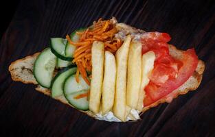 Doner with a crispy crust and delicious meat and vegetable filling on a dark background. photo