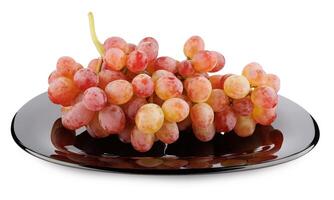 A juicy beautiful bunch of grapes lying in a black plate isolated on a white background. photo