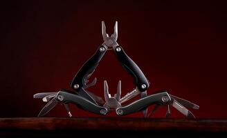 Steel open multitool on red background. Multitool with many useful tools. photo