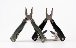 Steel multitool isolated on white background. Opened multitool with pliers, file, blade, screwdriver, bottle opener and saw, with a white background. Multi tool with expanded tools and pliers photo