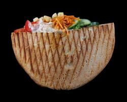 Doner with a crispy crust and delicious meat and vegetable filling on a dark background. photo