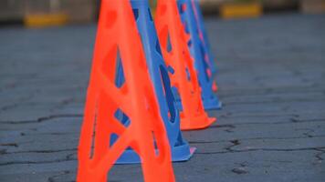 Orange cones and blue cones set up on a blue field for high school sports speed drills. photo