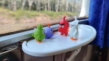 little angrybirds figure toys on the train table infront of window photo
