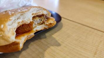 the bitten hamburger is isolated the burger is cut. unhealthy eating concept. photo