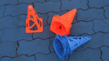 Orange cones and blue cones set up on a blue field for high school sports speed drills. photo