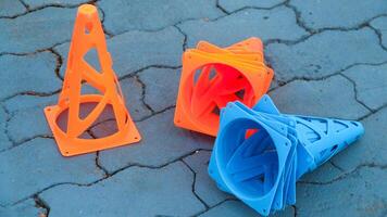 Orange cones and blue cones set up on a blue field for high school sports speed drills. photo