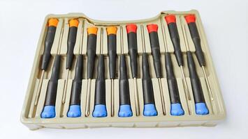 Set of red-orange-blue screwdrivers isolated on white background. Builder's and electrician's tools. Equipment. Set of steel screwdriver bits with red and black plastic handles. photo