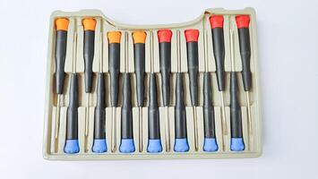 Set of red-orange-blue screwdrivers isolated on white background. Builder's and electrician's tools. Equipment. Set of steel screwdriver bits with red and black plastic handles. photo