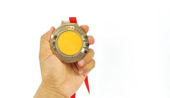 The winner's gold medal is held in the athlete's raised hand on a white background photo