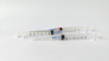 Vial of Drug or Vaccine and 3 ml Plastic Syringe with Needle Isolated on the White Background, blue tone color photo