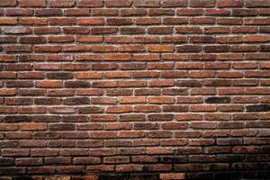 A brick wall with a brown color. The wall is made of bricks and has a rough texture photo