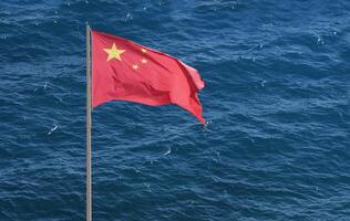 Chinese national flag at the coast near the sea photo