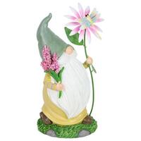 A gnome statue with a flower and a butterfly photo
