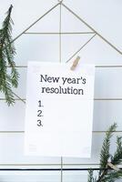 Vision board with NEW YEAR'S RESOLUTION aims goals on paper note. Preparation for New Year. Concept of planning and setting goals for personal development photo