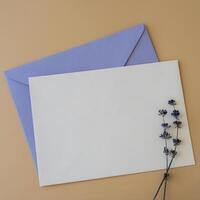 Empty white envelope paper card note template mock up. Copy space for your text. Lavender flower. Greeting or invitation card blank with envelope. Top view, flat lay photo