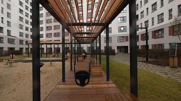 A large house with a playground. Stock footage. A beautiful new building next to which there are swings and benches for recreation. video