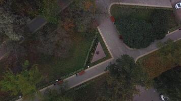A quiet evening empty park. Clip. Helicopter view of the resting area with benches, roads and a fountain. video