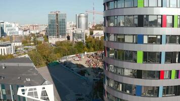 Modern high-rise building on background of stadium construction. Stock footage. View of modern city with high-rises and stadium construction site. Urban landscape with modern high-rises and video