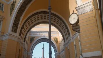 Beautiful old arch with view of monument. Action. Beautiful corridor of street arch of ancient building. Architecture of arched passage of ancient building on city square video