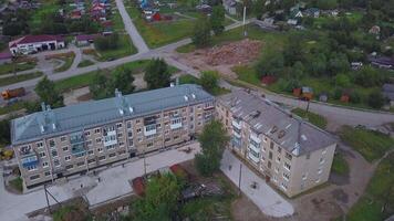 Bird's-eye view of a small town. Clip. A green area with small houses and overgrown green trees around. video