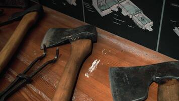 Analysis of items for repair. Media. Huge axes and iron keys that lie on the table next to the wall charts. video