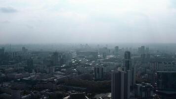 Top view of panorama of city in fog with sunlight. Stock footage. Beautiful view of panorama of city in fog on cloudy day. Urban landscape with horizon and fog video