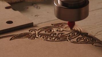 Carving geometric pattern on wooden sheet with small drill at woodwork factory, macro view. Creative. Wood lathe machine processes detail creating sawdust. video