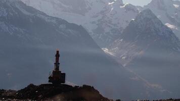 Mining industry concept. Creative. Quarry, opencast mining, ore extraction, working excavator in front of giant mountains. video