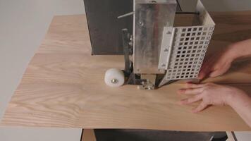 Close-up of worker cutting wooden board with machine. Creative. Homemade machine for discharging wooden boards in workshop. Man cuts wooden board with machine tool in creative workshop video