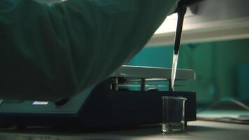 Working with chemical elements. Stock footage. Green medicine in test tubes with working scientists in a specially isolated room. video