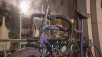 Vintage bicycle with chain at store. Action. Antique bicycle stands at window of store. Old rusty bicycle stands outside building on sunny day video
