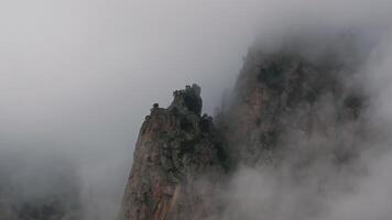 Clouds are moving around the peak of a mountain video