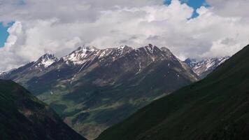 Clouds passing over snow capped mountains video