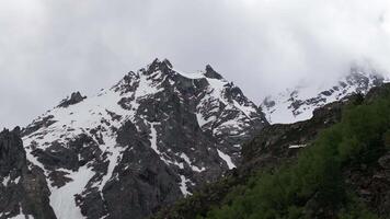 Clouds passing over snow capped mountain peaks video