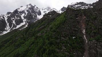 Clouds are slowly passing over a snowy mountain peak video