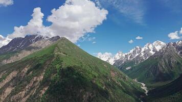 White clouds are slowly passing over a green mountain valley video