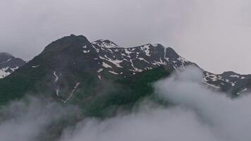 Clouds are moving over the peak of a mountain video