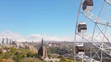 Yerevan, Armenia - 19th october, 2024- Aerial static view ferris wheel in Victory Park with cityscape and buildings of Yerevan. Sunny autumn day carousels day out things to do concept video