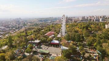 Yerevan, Armenia - 19th october, 2024- Aerial static view visitors ride in carousels in amusement Victory Park in Sunny autumn day. Travel and things to do visit Yerevan concept video