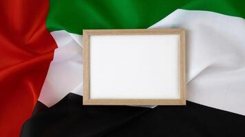 Empty white paper frame template National symbol of UAE. United Arab Emirates small flag with Peregrine falcon on neutral beige background. Copy space for your text. Concept of National day Independence photo