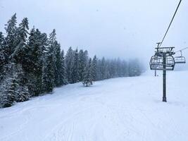 esquí levantar Nevado montaña invierno bosque con silla levantar a el esquí recurso en invierno. Nevado clima esquí Días festivos invierno deporte y al aire libre ocupaciones al aire libre turismo esquiar Snowboarding foto
