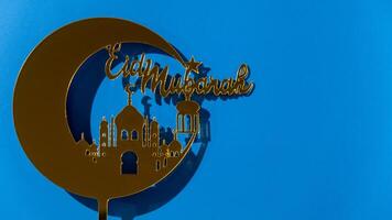 Crescent moon at top of mosque. Eid Mubarak text creative conceptual poster design for advertising branding. Mock up template for greeting card postcard. Ramadan Kareem background. Traditional muslim holiday. Copy space photo