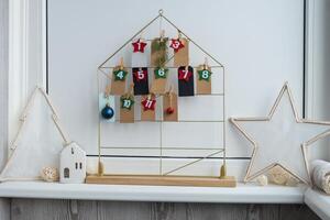 Number on craft paper notes with tasks before Christmas holidays. Female making kraft paper for handmade advent calendar Made with your own hands step by step DIY crafts do it yourself photo