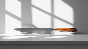 Large chef knife with wooden handle resting on white surface photo