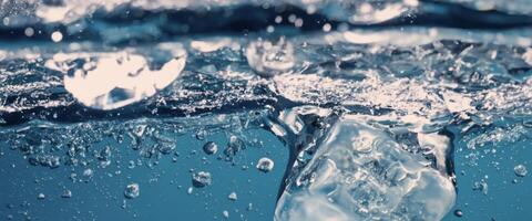 Water splashing and ice cube. Ice splashing into a glass of water. Underwater pouring ice cubes falling into clear watering background. Refreshing chill drinking. Ices in a glass with blue background photo