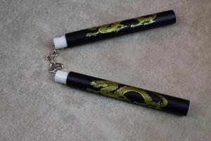 Training nunchucks made of soft material with dragon image for training martial arts at home, training weapon on light background, development of agility skills at home, martial arts culture photo